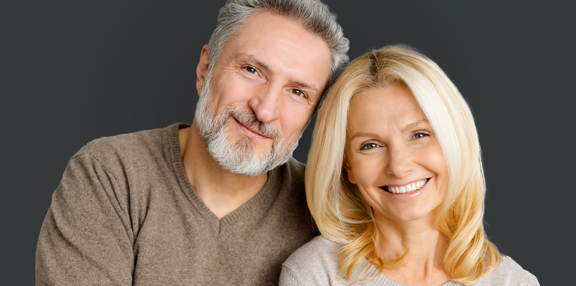 The image shows a man and woman posing together with smiles, likely a family portrait.